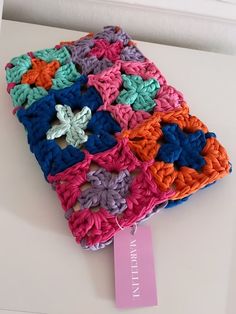 a colorful crocheted square with a tag on it