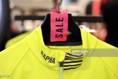 neon yellow jacket with pink sale tag hanging from it's collar in a store