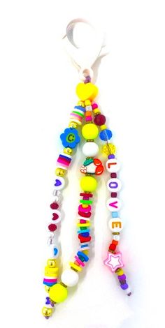 a colorful beaded keychain hanging on a white wall with the word love spelled in beads