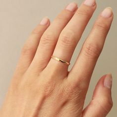 A simple 2mm gold band crafted in 14k yellow gold, for all your stacking needs. Wear it solo, as a simple vow ring, or stacked playfully with our other gold ring options. Either way, you can't go wrong. This style is made to order and will take 2-3 weeks to ship. Crafted in San Francisco using ethically sourced materials. *All sales are final* Everyday Tiny Stackable Rings In 14k Gold, Dainty 14k Gold Toe Ring, Adjustable 14k Gold Bands For Everyday, Adjustable Yellow Gold Stackable Rings With Simple Design, Dainty Round Band Rings For Everyday, Dainty Stackable Rings In Recycled Gold For Promise, Delicate Everyday Stackable 14k Gold Rings, Dainty Recycled Gold Stackable Rings For Promise, Everyday Delicate 14k Gold Stackable Rings