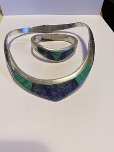 "This is a striking, vintage, genuine Taxco multi stone and sterling silver hinged bangle bracelet that was handmade in Taxco, Mexico. It has genuine lapis lazuli and malachite inlaid in the sterling silver. The bracelet has the inlaid stone in different shapes, giving it a geometric feel. The inner circumference of the bracelet is about 7\". It measures about 2 1/2\" by 1 3/4\". The bracelet face is about 3/4\" then is about 3/8\" on the back. It weighs about 40 grams and is stamped TF-48 Mexic Vintage Bangle With Natural Stones, Vintage Natural Stones Jewelry For Anniversary, Vintage Jewelry With Natural Stones For Anniversary, Sterling Silver Hinged Jewelry For Gifts, Sterling Silver Hinged Jewelry Gift, Vintage Sterling Silver Multi-stone Jewelry, Vintage Sterling Silver Bracelets With Natural Stones, Vintage Sterling Silver Bracelet With Natural Stones, Vintage Multi-stone Sterling Silver Jewelry