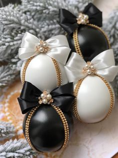 three black and white eggs with bows on them