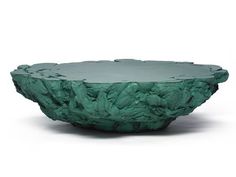 a green bowl sitting on top of a white table