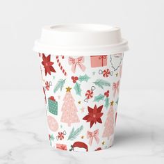 a paper cup with christmas decorations and bows on the lid is sitting on a marble surface