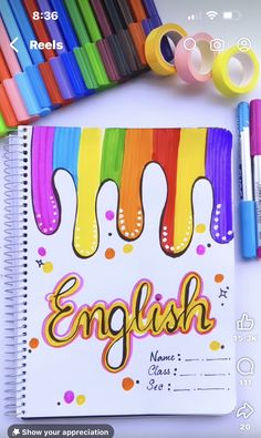 an open notebook with the word english written on it and colored crayons next to it