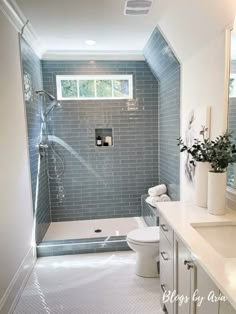 a bathroom with blue tiles and white fixtures