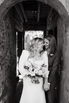 a bride and groom standing in an archway