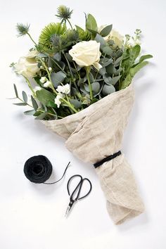 a bunch of flowers that are sitting on a table with some scissors next to it