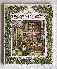 the secret staircase book cover with an illustration of cats in a kitchen surrounded by ivy