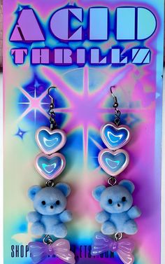 Add a touch of pastel goth cuteness to your outfit with these unique Blue Fuzzy Teddy Bear Kawaii Dangle Earrings! Featuring adorable heart beads and a sweet bow charm, these earrings are perfect for anyone who loves all things kawaii and cute. Stand out from the crowd with these one-of-a-kind accessories that are bound to make you smile every time you wear them. These handmade dangle earrings feature Cute AF fuzzy blue teddy bears adorned with pastel hearts and bows as sweet as candy. Get your Handmade Blue Kawaii Jewelry, Cute Blue Jewelry With Heart Charm, Cute Blue Jewelry For Valentine's Day, Trendy Blue Heart Earrings For Gift, Cute Blue Jewelry With Heart Beads, Blue Cute Drop Earrings, Blue Drop Earrings Cute Style, Blue Drop Earrings Cute Jewelry, Cute Blue Heart Jewelry