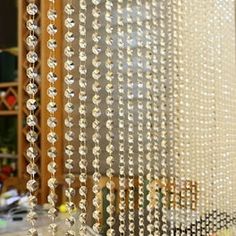 beaded curtains are hanging in front of a window with beads on the outside and inside