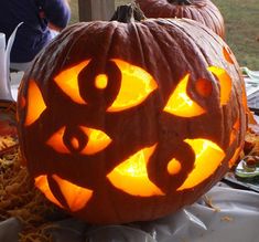 two carved pumpkins sitting on top of a table