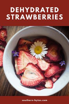 strawberries in a white bowl with flowers and daisies on the side text reads, dehydrated strawberries