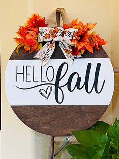 a wooden sign that says hello fall hanging on a wall