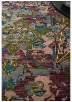 an area rug with various colors and patterns on it, including blue, pink, green, purple, yellow