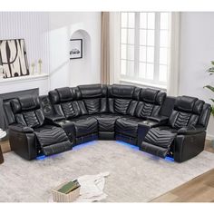 a living room filled with black leather couches and recliners on top of a white rug