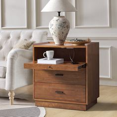 a living room with a couch, table and lamp on it's end table