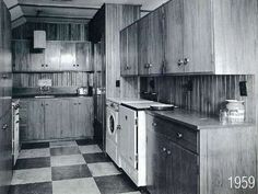 an old black and white photo of a kitchen with wood paneling on the walls