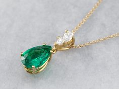 This lovely necklace was crafted in our shop, using both vintage and modern pieces. The center gem is a deep, gorgeous green emerald from our collection! We've used a brilliant diamond as an accent, and set them both in a simple yellow gold pendant with clean, simple lines. Set perfectly on a yellow gold rolo 16-inch chain, making this stunning piece ready to wear or gift! Metal: 18K Yellow Gold Gem: Emerald 2.57 Carats Gem Measurements: 12.0 x 8.2 mm, Pear Cut Accents: Diamond .42 Carats, F in Pear-shaped Emerald Necklace For Formal Events, Fine Jewelry Emerald Pear-shaped Necklace, Elegant Green Pear-shaped Diamond Necklace, Emerald Pear-shaped Necklace For Wedding, Emerald Pear-shaped Wedding Necklaces, Fine Jewelry Emerald Necklace With Brilliant Cut, Emerald Necklace In Brilliant Cut, Fine Jewelry Green Emerald Necklace With Brilliant Cut, Exquisite Green Necklace With Brilliant Cut