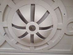 the inside of a white ceiling with circular designs on it's sides and an opening in the center