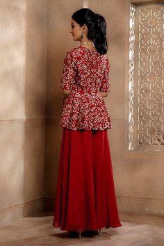 Ruby red peplum top with thread embroidery in floral pattern and cutwork border. Paired with sharara.
Components: 2
Pattern: Embroidery
Type Of Work: Thread, flower
Neckline: V neck
Sleeve Type: Half
Fabric: Peplum - Cupro Raw Silk, Sharara - Viscose Satin Organza
Color: Red
Other Details: 
Cutwork border
Closure: Sharara: Button
Occasion: Sangeet - Aza Fashions Top And Sharara Set, Silk Sharara, Red Peplum Tops, Flower Top, Red Thread, Sharara Set, Pattern Embroidery, Thread Embroidery, Flower Tops