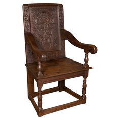 an old wooden chair with carvings on the back and arm rests against a white background