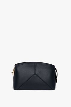 The latest addition to the house’s leather goods edit, this luxuriously textured clutch bag in refined Navy is a favourite of Victoria’s. Featuring a structured silhouette with an elegant curved top, it has several notable features, including a branded padlock serving as zipper and closure, a snap button at one side to hold the zip tail in place and leather panels stitched to form a V shape. A flat internal pocket ensures secure storage of smaller items. Victoria Beckham Exclusive Victoria Cross Elegant Leather Travel Cosmetic Bag, Elegant Soft Leather Crossbody Clutch, Elegant Leather Cosmetic Bag For Business, Leather Rectangular Cosmetic Bag For Evening, Elegant Shoulder Clutch In Soft Leather, Elegant Soft Leather Shoulder Clutch, Elegant Soft Leather Clutch As Shoulder Bag, Chic Evening Pouch Cosmetic Bag, Chic Evening Cosmetic Pouch Bag