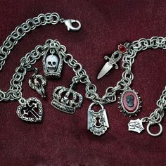 Yes, my darlings, you've won the dark lottery...It sold out at Viva Las Vegas. Now it's back in stock...Dark, sophisticated glamour. A chain of dimensional Loteria symbols are suspended from the vintage double rolo chain:Enameled Serpent Glass Skull, Gothic crown, Dungeon Padlock,Blood Red Cameo Cross of Darkness. Closes with a large rope ring and clasp with Elvira spider web tag. Hematite and crystal accents Created in our Los Angeles studio. 18" Long Objects of desire: the Elvira Jewelry Collection Elvira's many fans and admirers frequently ask for advice on how to give their own look a little edge. Her secret is jewelry. Now, everyone's favorite Vamp brings her special brand of magic to women worldwide, conjuring up mystery, seduction and glamour. Her collaborator is American designer a Glamorous Goth, Goth Queen, Gothic Crown, Goth Necklace, Rope Ring, Hippie Wedding, Vintage Goth, Locket Bracelet, Goth Jewelry