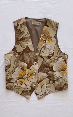 SALES! -40% From €45.00 to €27.00 PENNYBLACK vintage waistcoat in 100% beige linen, warm toned flower pattern. Classic waistcoat fit, just hip length, V-neck, side pockets. Three mother-of-pearl buttons. Back in silk-effect polyester, buckle to adjust. Defect: the internal lining is a little faded (see photo). Composition: Body 100% linen, Lining 100% polyester. Size Size 46 IT Fits best Italian 42/44 English 10/12 French 38/40 International S/M/L MEASUREMENTS MEASUREMENT (taken lying on a table Retro V-neck Vest For Spring, Spring Floral Print V-neck Vest, Vintage V-neck Vest For Spring, Beige Linen Spring Vest, Retro V-neck Spring Vest, Spring V-neck Retro Vest, Fitted Cotton Vest With Floral Print, Fitted Vintage V-neck Vest, Vintage Fitted Vest For Spring