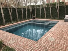 an empty pool surrounded by brick walls and trees