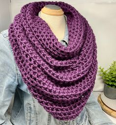 a woman wearing a purple crocheted scarf on top of a mannequin