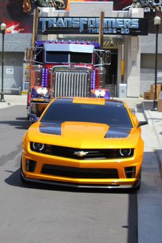 a yellow car is driving down the street in front of a firetruck truck