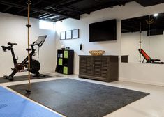 an indoor gym with exercise equipment and television