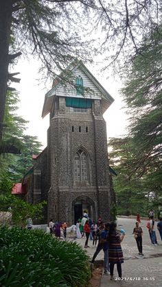 people are standing in front of an old church