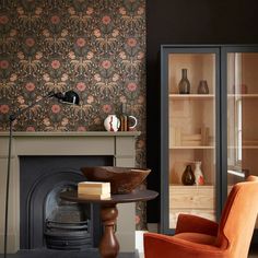 a living room filled with furniture and a fire place in front of a wallpapered fireplace