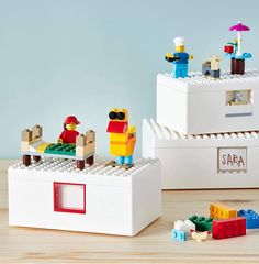 two legos sitting on top of each other in front of a white box filled with toys