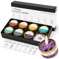 the seven chakra scented candles are in a black box and one candle is lit