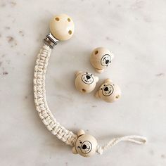 three wooden beads with faces on them sitting next to each other in front of a marble surface