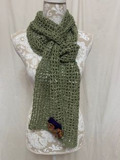 This lovely light olive green scarf has bits of ivory silk throughout the yarn, giving it a texture and softness the photos can't convey. The darling little flowers give it a spring feel....even if Mother Nature may not cooperate, at least you get to add some flowers to your day! At 90" long, this one is super versatile and can be wrapped, knotted, and tied many ways....because it's a light-weight 40% merino, 40% alpaca, 20% silk, it is amazingly soft! All items are created in our smoke-free home with careful attention to quality. I have been crocheting for over 40 years and am happy to chat with you about custom-creating one-of-a-kind afghans, scarves, etc. Note that colors may appear differently on your screen. Green Bohemian Scarf For Spring, Green One Size Scarf As A Gift, Green One-size Scarf As Gift, Elegant Green Scarf, One Size, Winter Green Yarn Scarves, Green Yarn Scarves For Winter, Handmade Green Shawl For Spring, Green Bohemian Scarf For Fall, Green Scarves For Winter Gifts