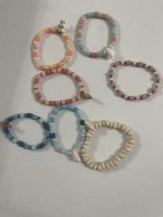 This is our beach bracelet collection! We have many different beach themed bracelets. They are all made with stretchy clear elastic string. Trendy Stackable Beaded Bracelets For Beach, Summer Beach Stackable Jewelry, Multicolor Stackable Stretch Bracelet For Beach, Beachy Summer Jewelry With Letter Beads, Adjustable Assorted Beach Bracelets, Adjustable Assorted Bracelets For Beach, Casual Strand Bracelets For Beach Party, Stackable Bracelets For Beach In Summer, White Adjustable Stretch Bracelet With Beachy Style