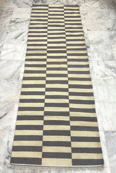 a black and white checkered rug on the floor in a room with marble floors