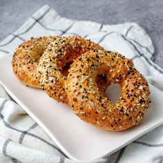 two sesame seed bagels on a white plate