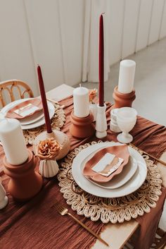 the table is set with candles, plates and napkins for an elegant dinner party