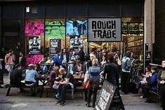 a group of people sitting on benches in front of a store