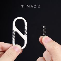 a person holding a small metal object in their left hand with the word timaze on it