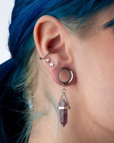 a woman with blue hair wearing ear piercings