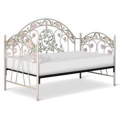 a white metal bed frame with pink flowers on the top and bottom, against a white background