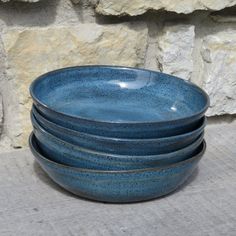 four blue bowls stacked on top of each other