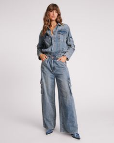 The BLUE BLOSSOM CARGO TRUCKER OVERALL is a masterpiece. At first glance it looks like a double denim delight but is a jumpsuit with a tucked in waist. Oversized with a fixed waistband that you can pull up or down depending on where you want it to sit. True to size, raw hem with inverted pleats to allow movement in the top half. Features some distressing on the back neck and some on the cuffs and finished off with gunmetal hardware.   BLUE BLOSSOM is our favourite new denim wash - a so Low Waist Skirt, Blue Blossom, Denim Jumpsuits, Adventurous Women, Boyfriend Fit Jeans, Gunmetal Hardware, Style Edit, Double Denim, Jumpsuit Online