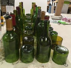 there are many green glass bottles on the table